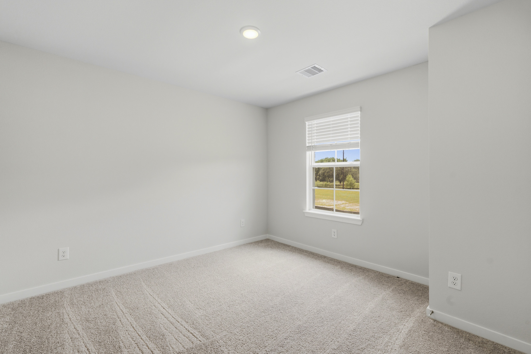 A room with a window and a carpet.