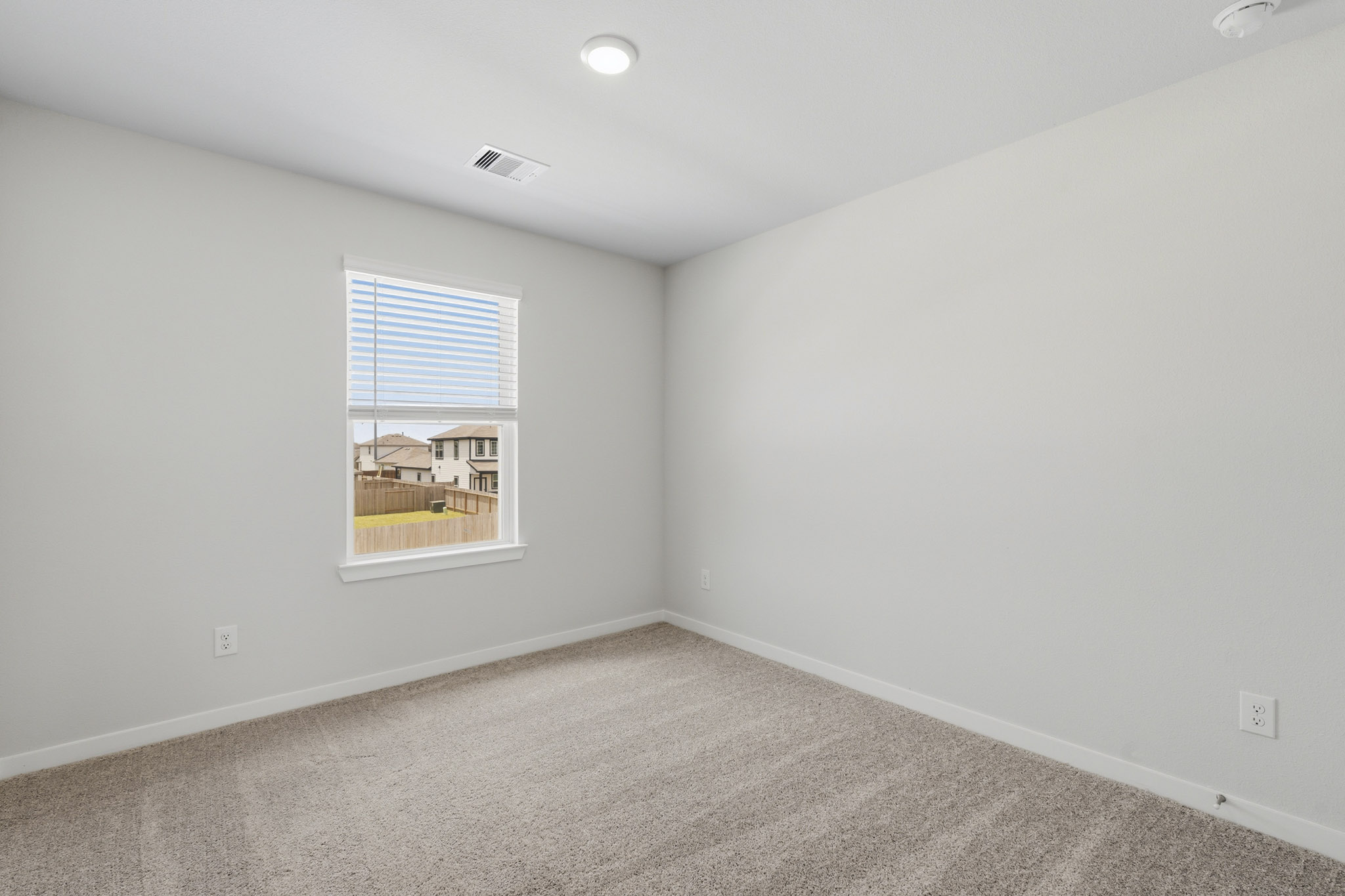 A room with a window and carpet.