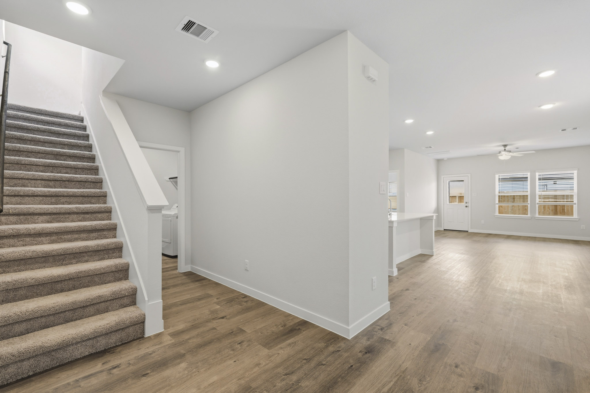 A large empty room with a staircase.