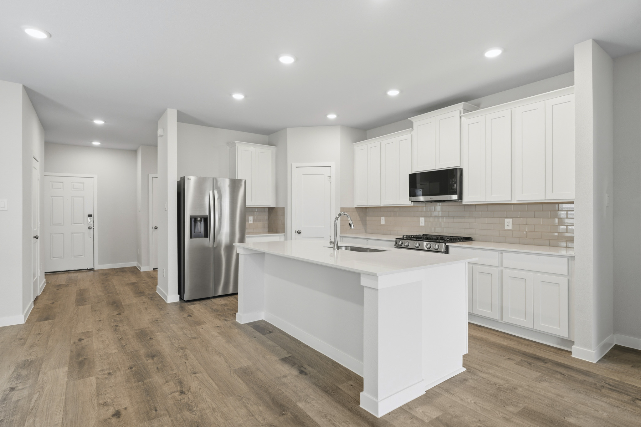 A kitchen with white cabinets.