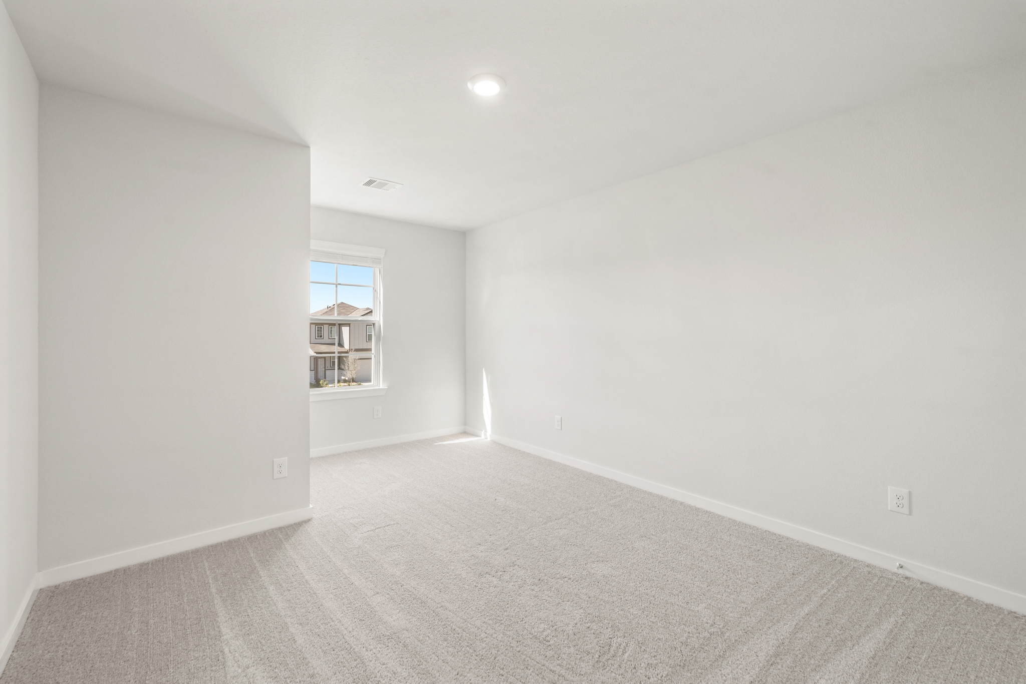 A room with a window and a carpet.