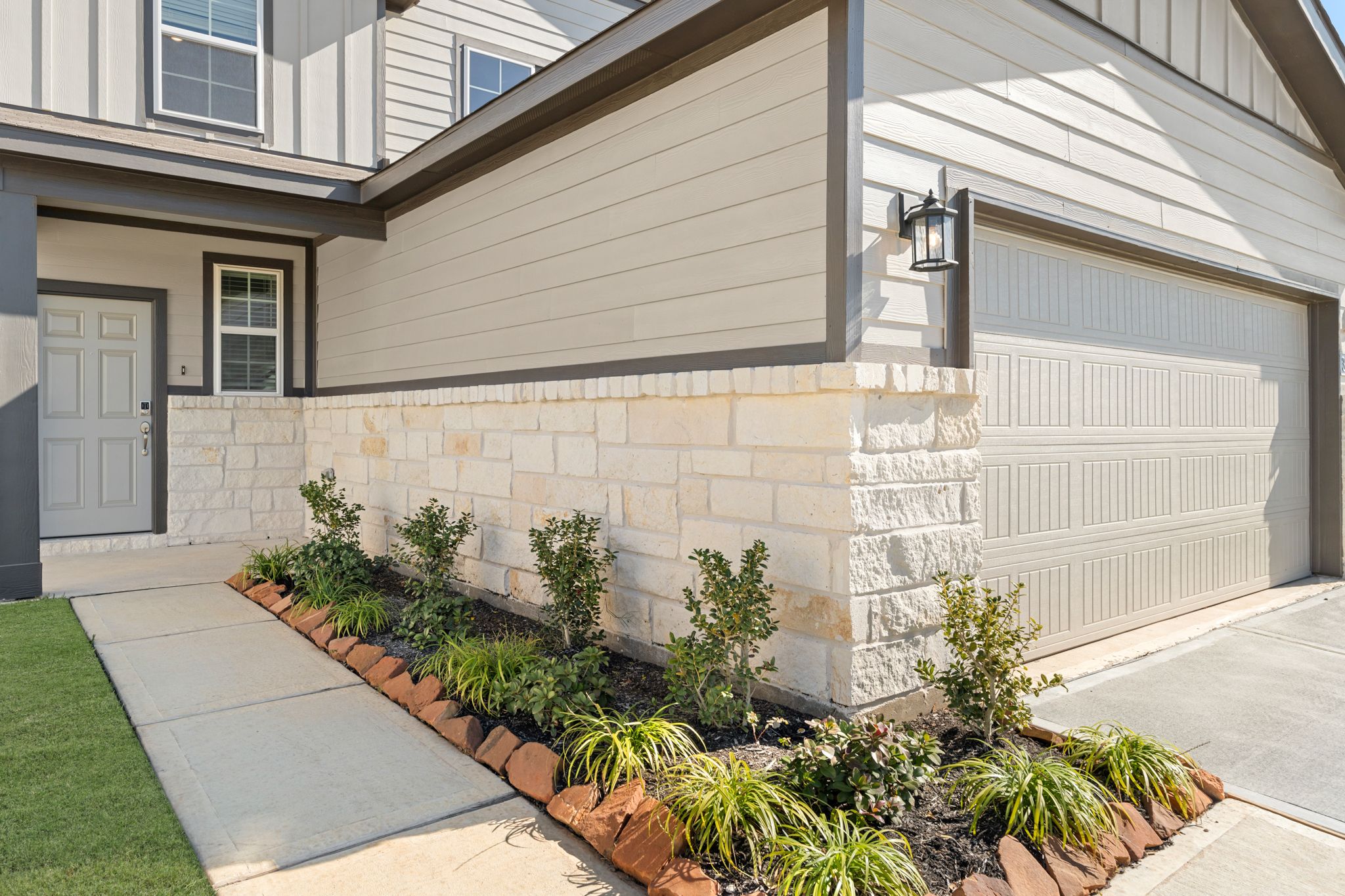 A house with a garage and a light on the side.
