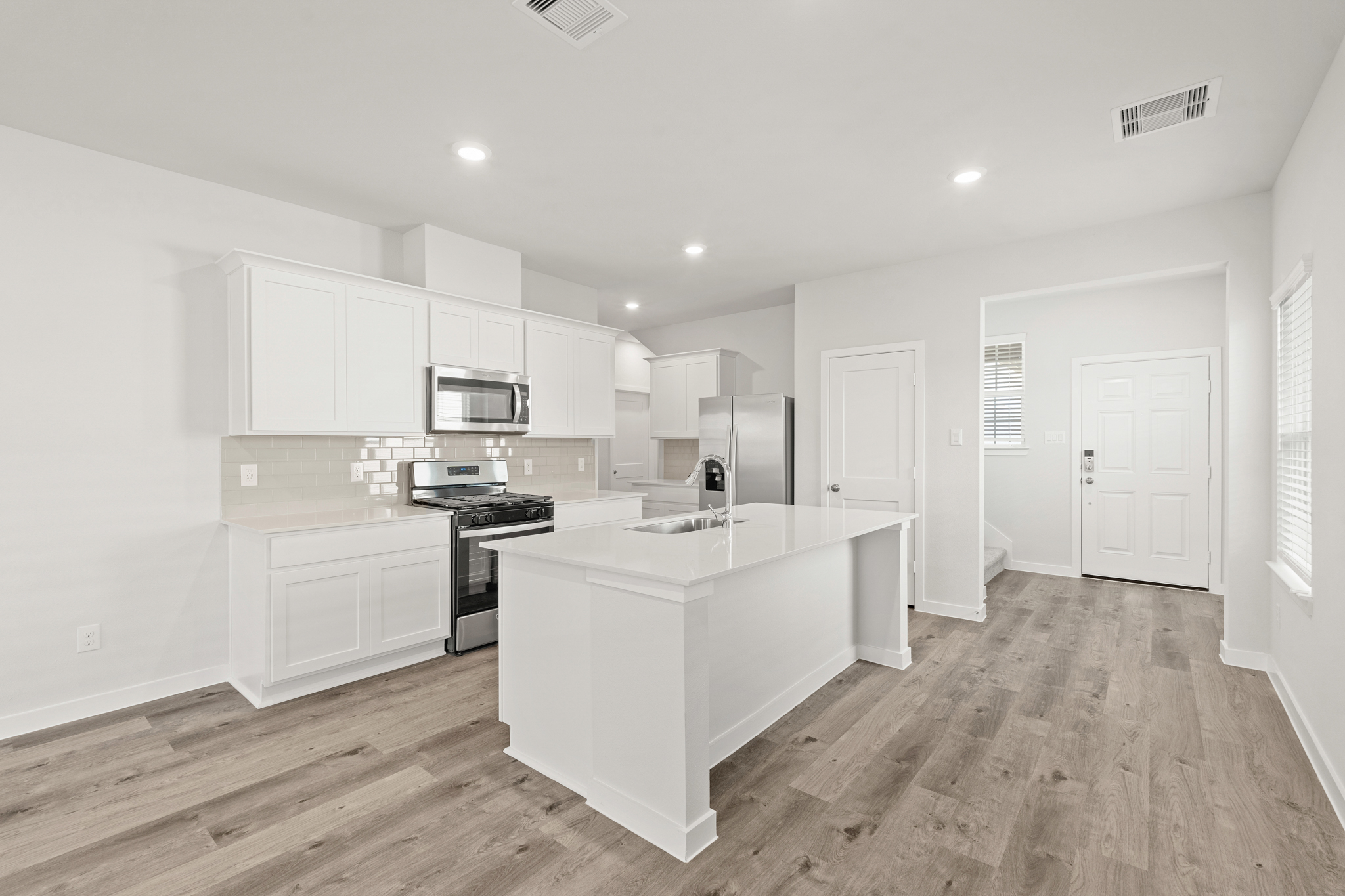 A kitchen with white cabinets.