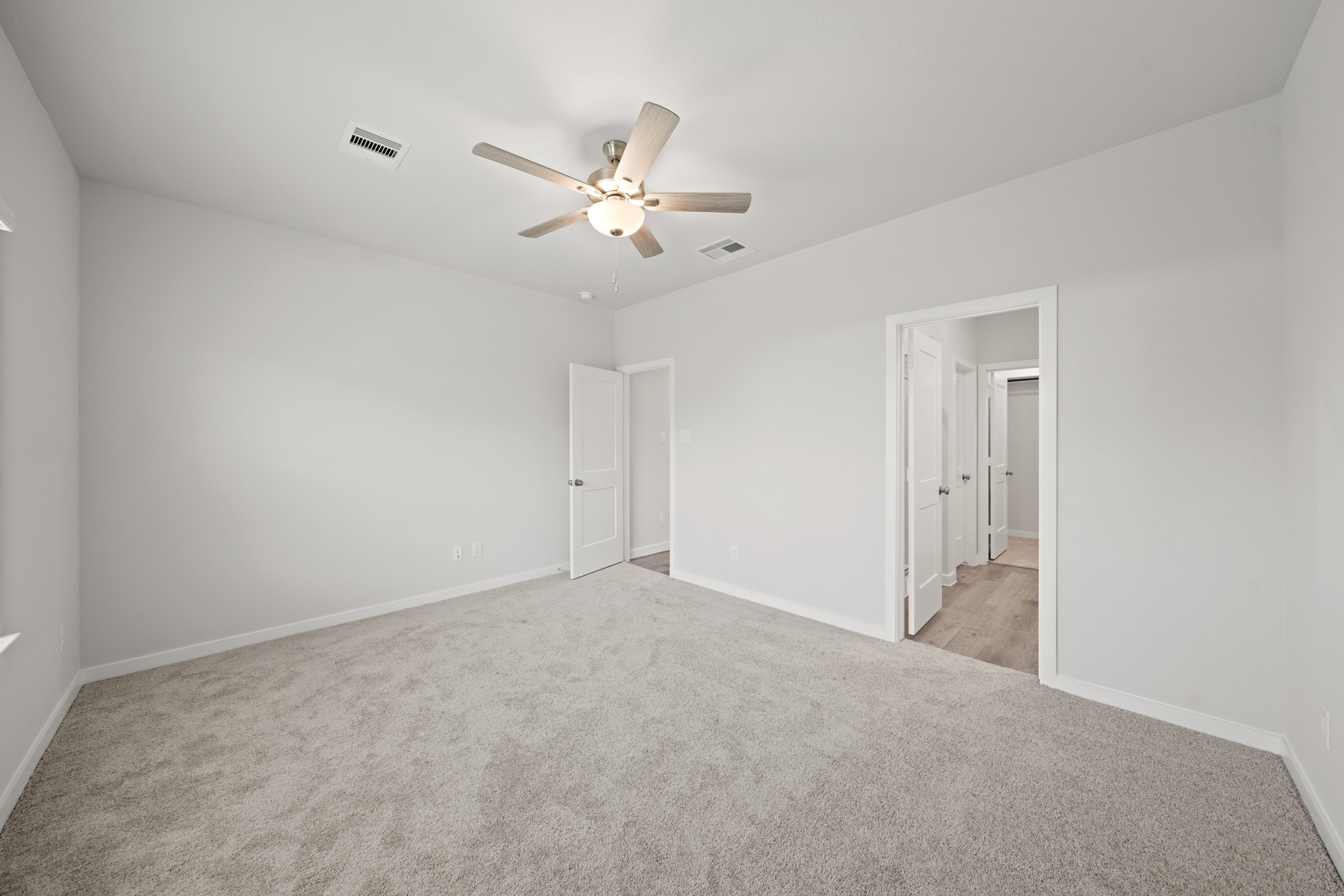 A room with a ceiling fan and a door.