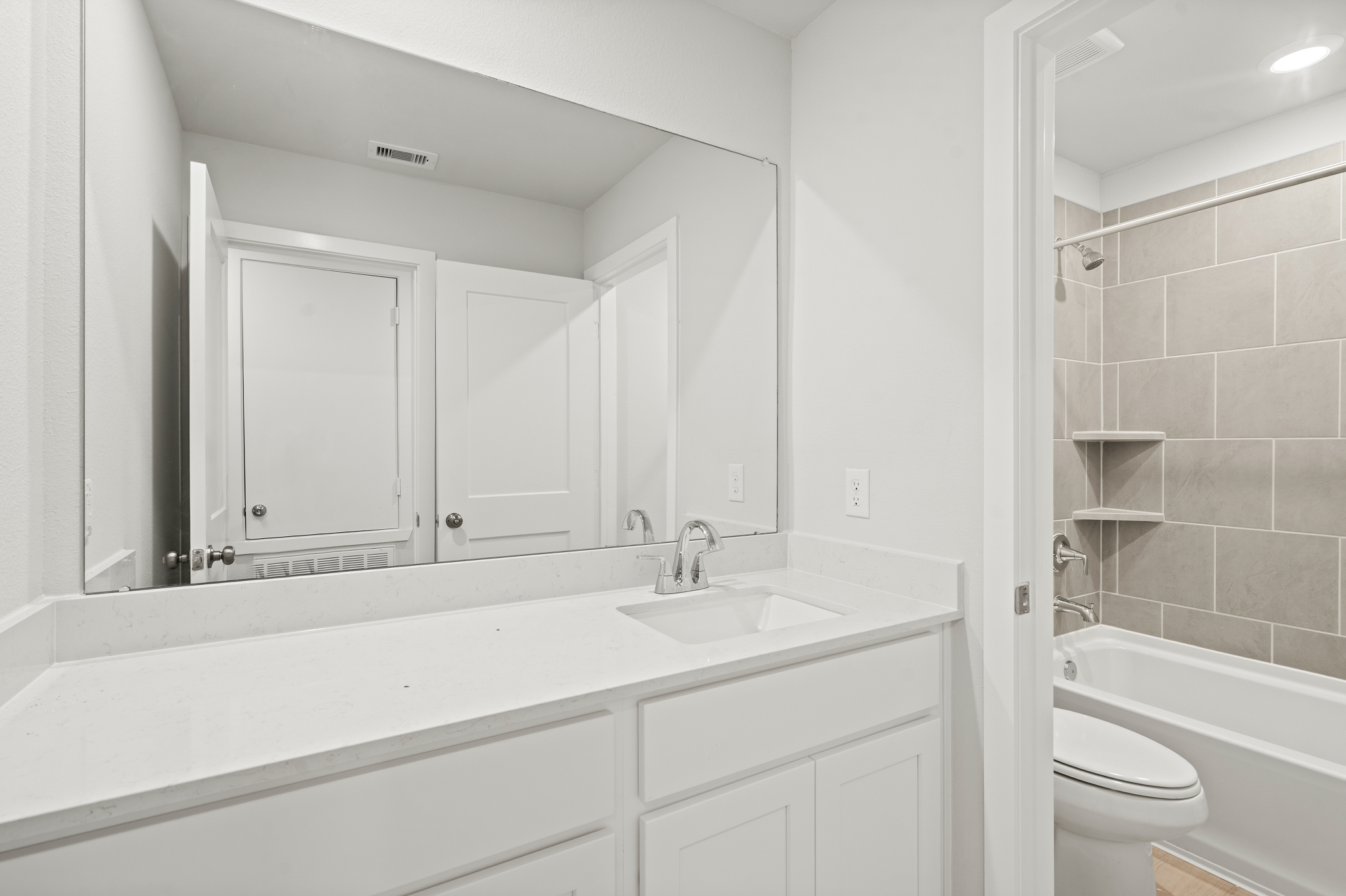 A bathroom with a tub sink and toilet.