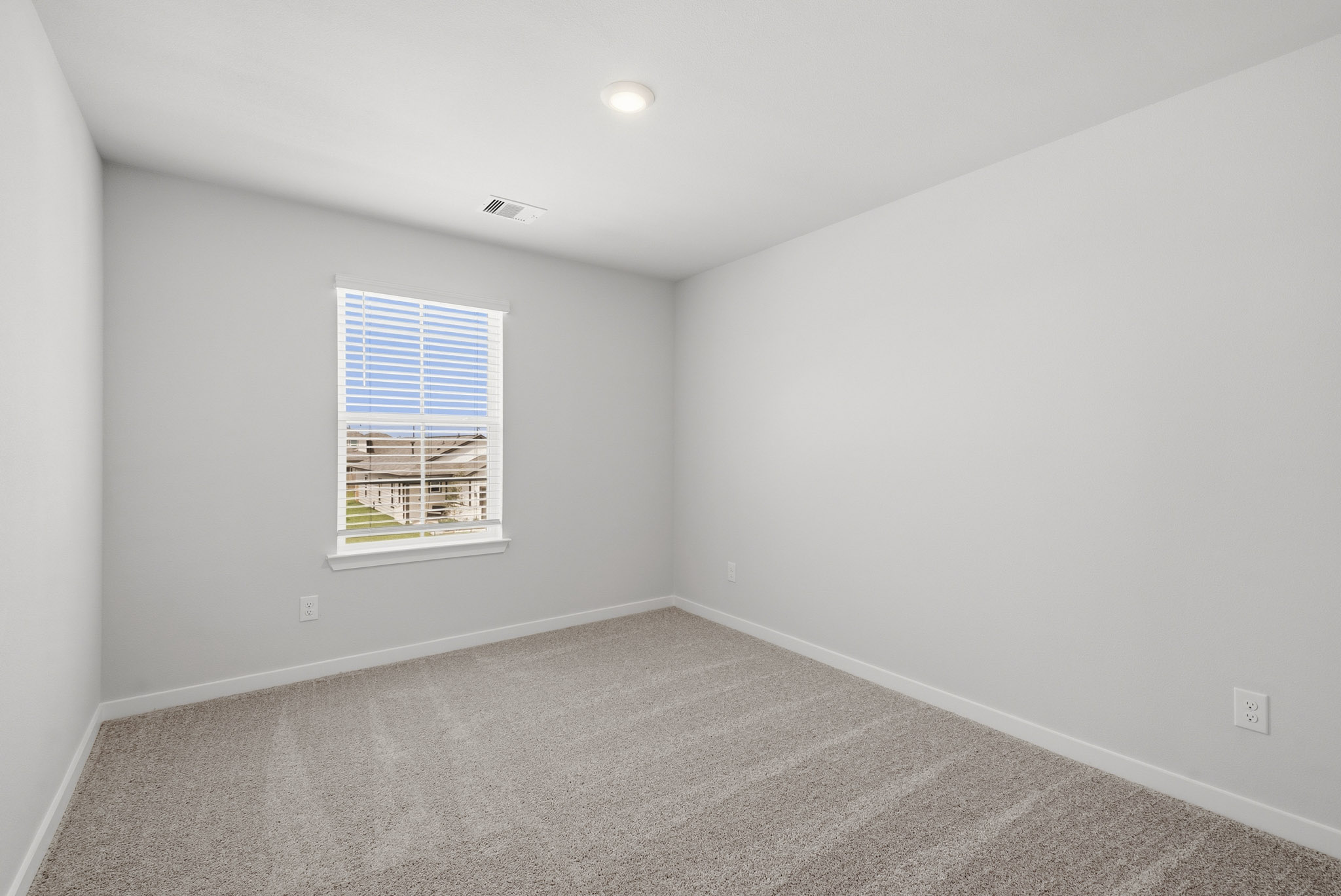 A room with a window and a carpet.