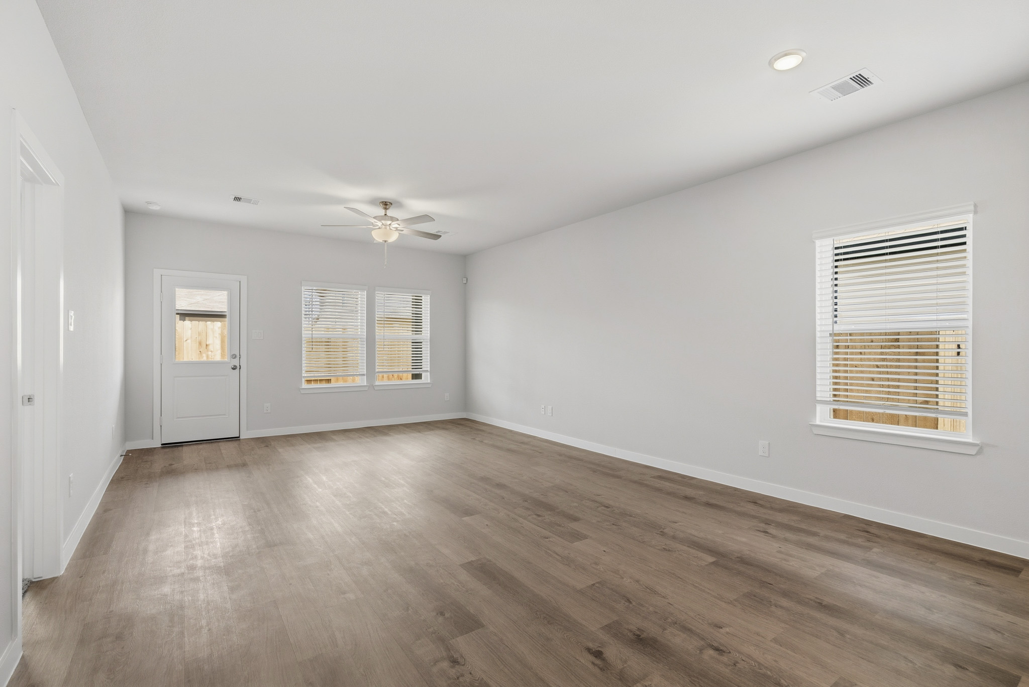 A room with a wood floor and a ceiling fan.