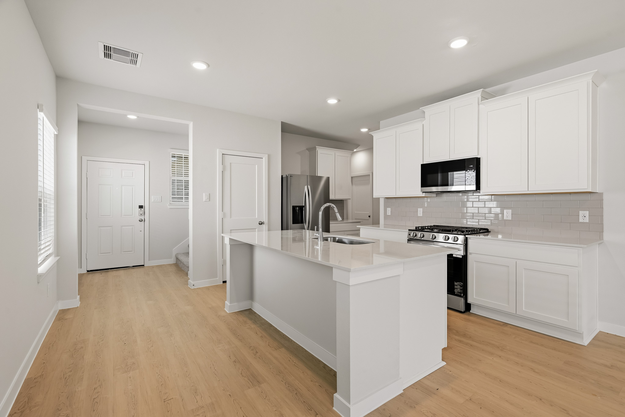 A kitchen with white cabinets.