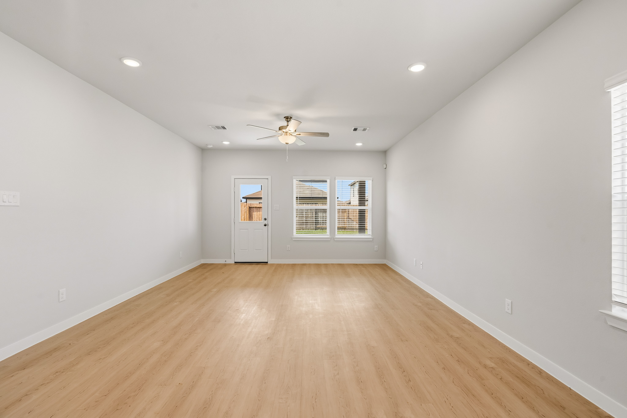 A room with a wood floor and a ceiling fan.