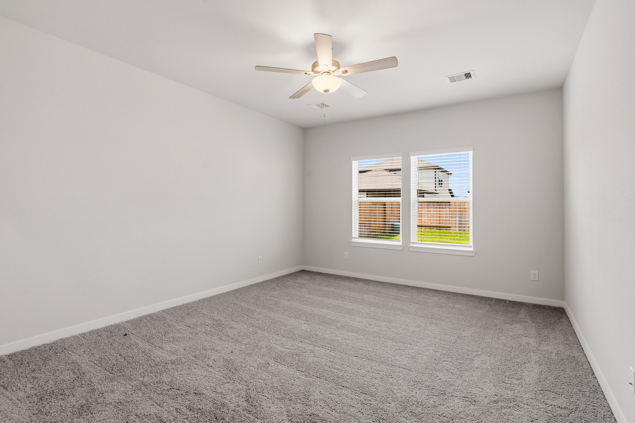 A room with a ceiling fan and a window.