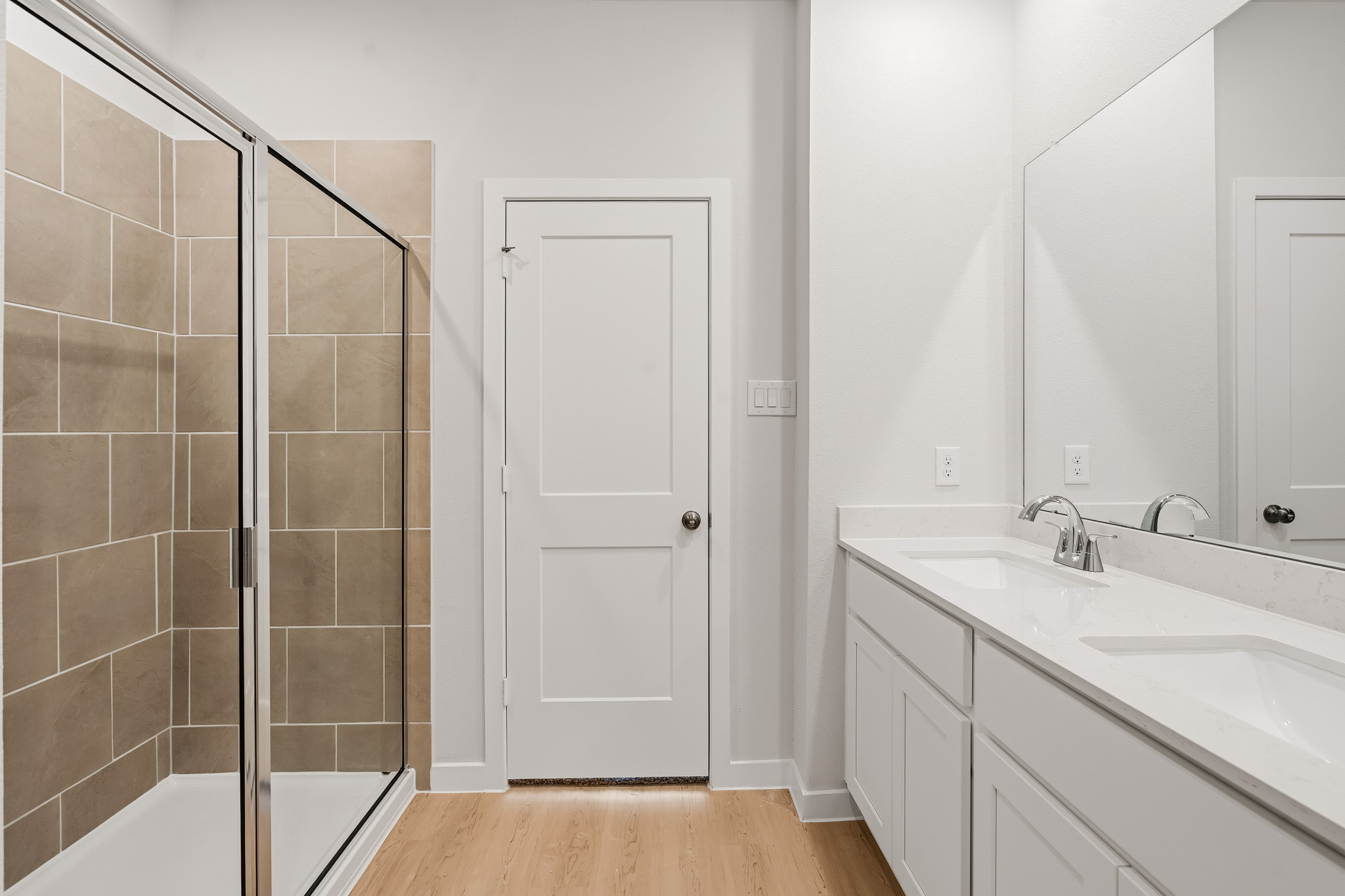 A bathroom with a sink and a shower unit.
