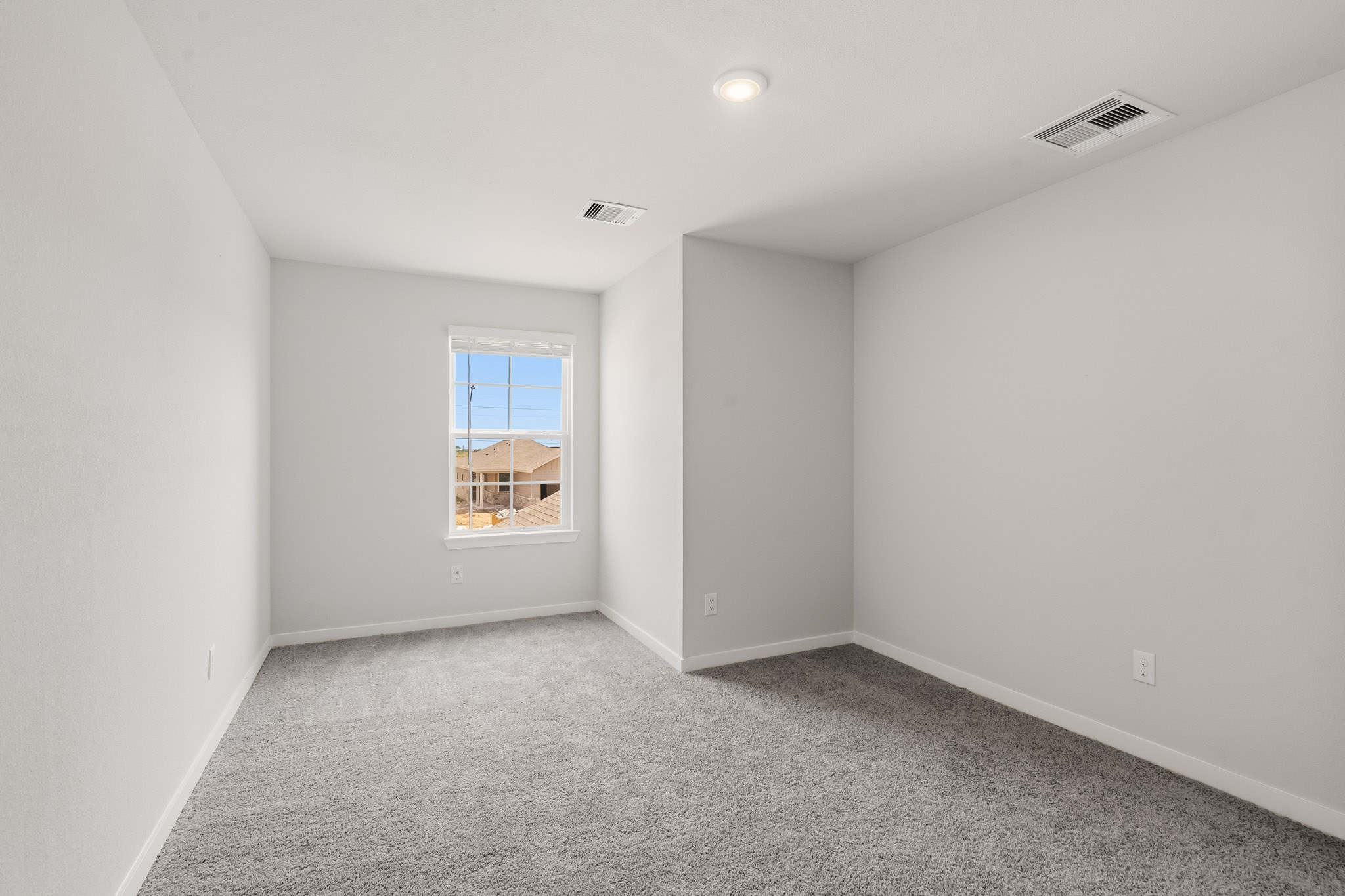 A room with a window and carpet.