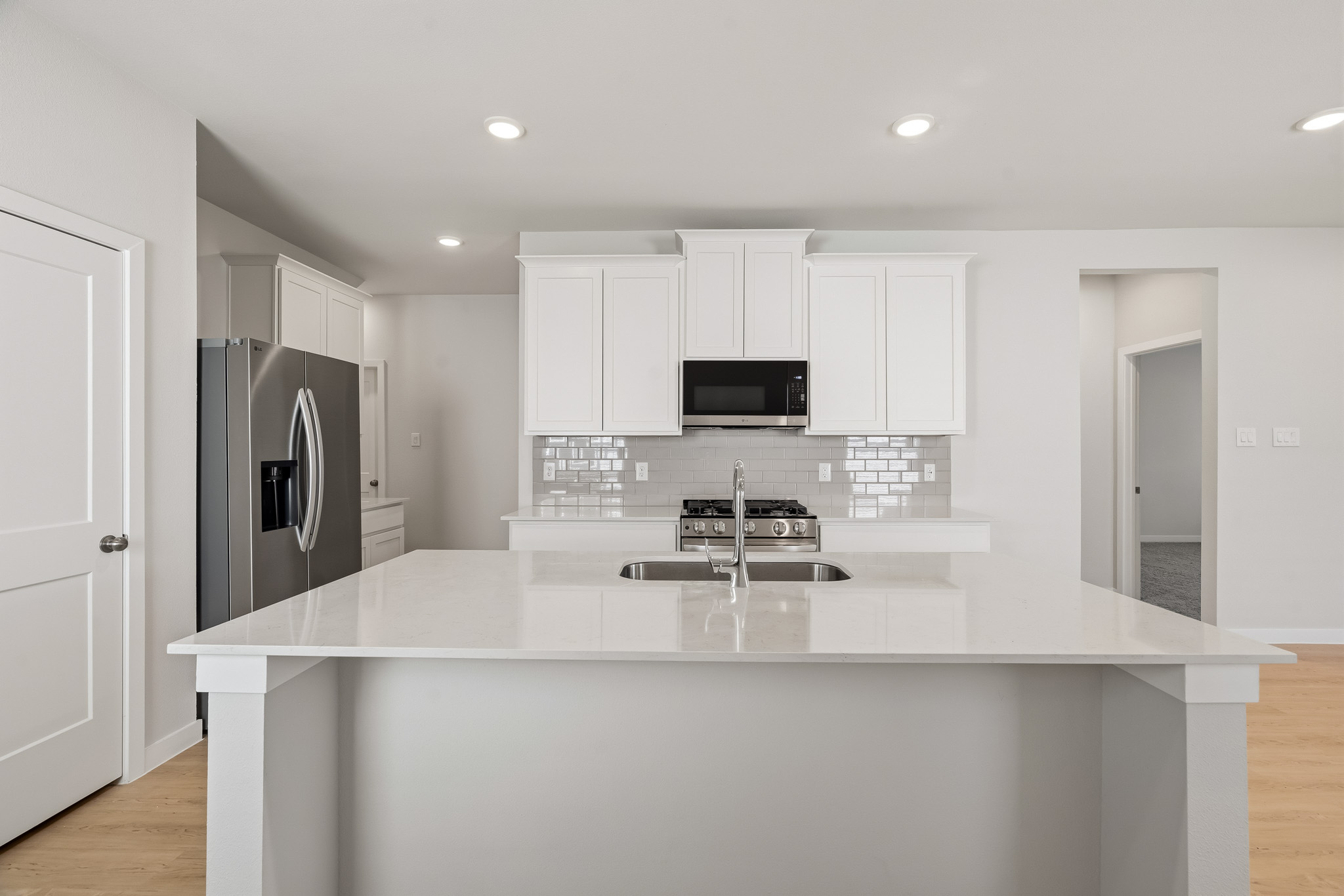 A kitchen with white cabinets.