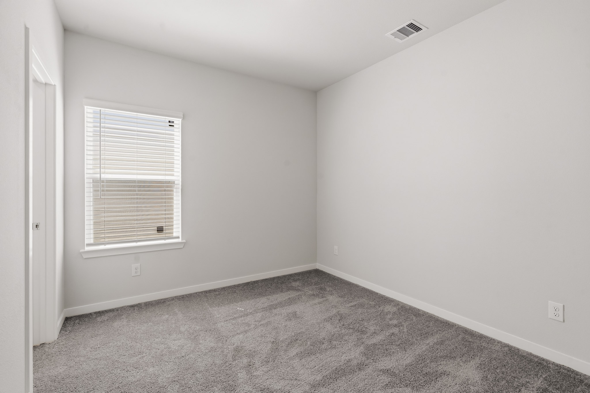A room with a window and carpet.