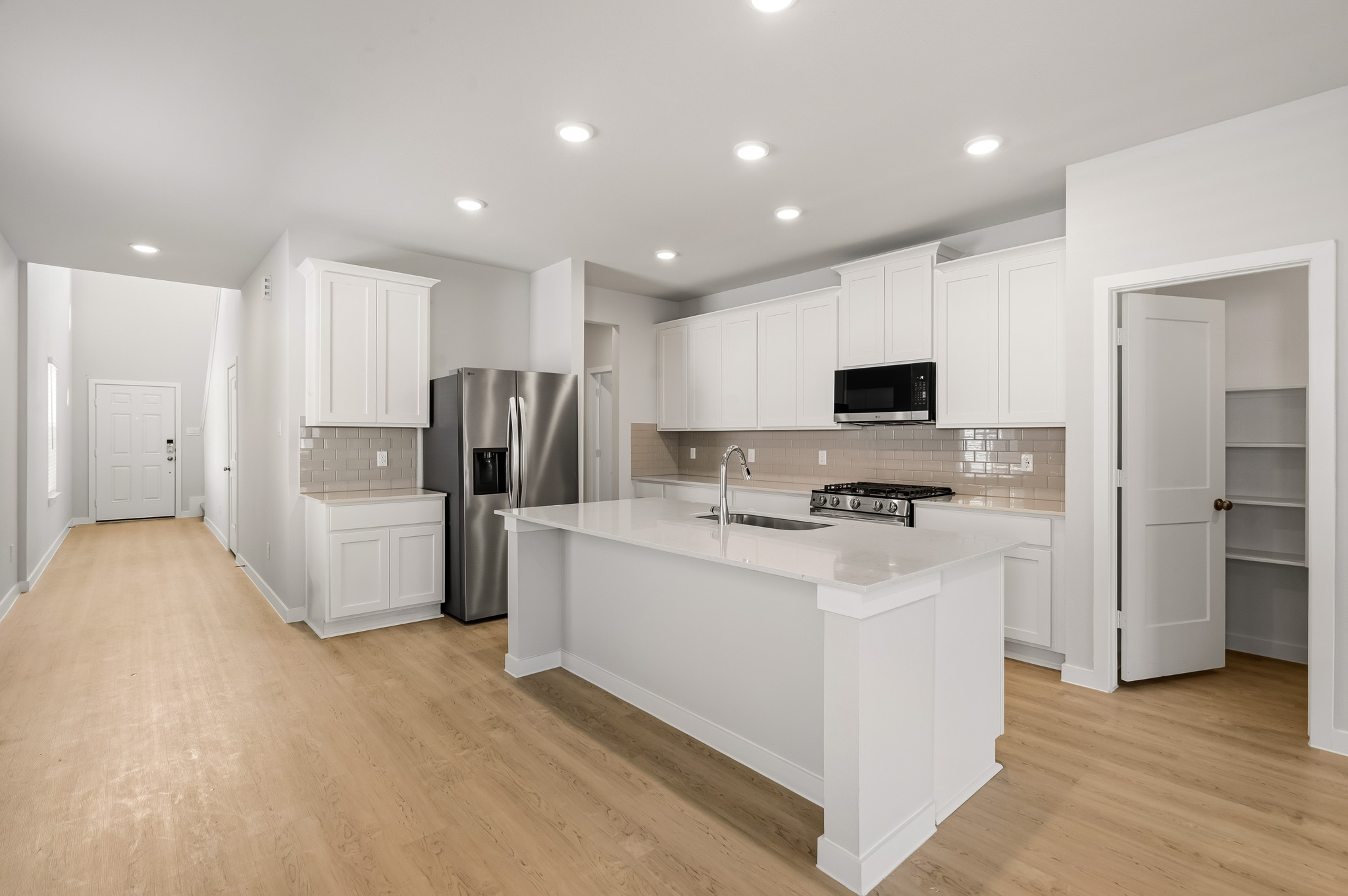 A kitchen with white cabinets.
