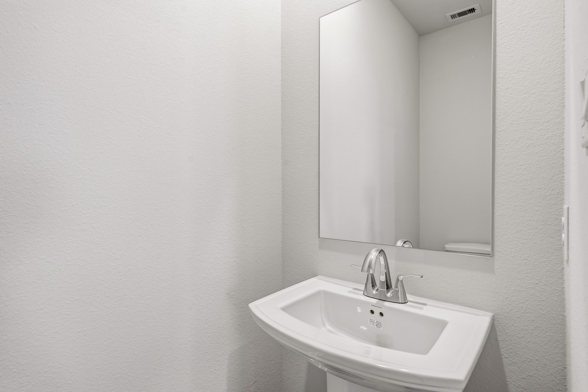 A bathroom with a large mirror.