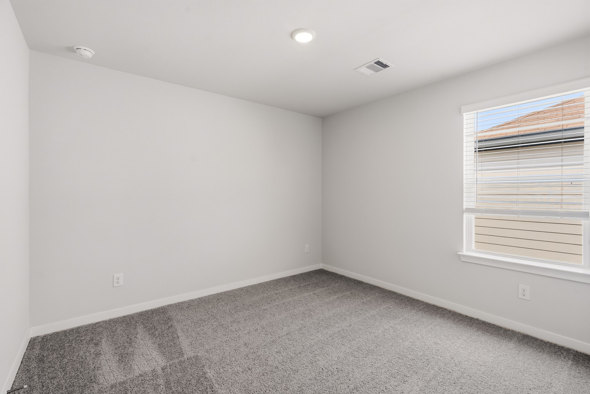 A room with a carpet and a window.