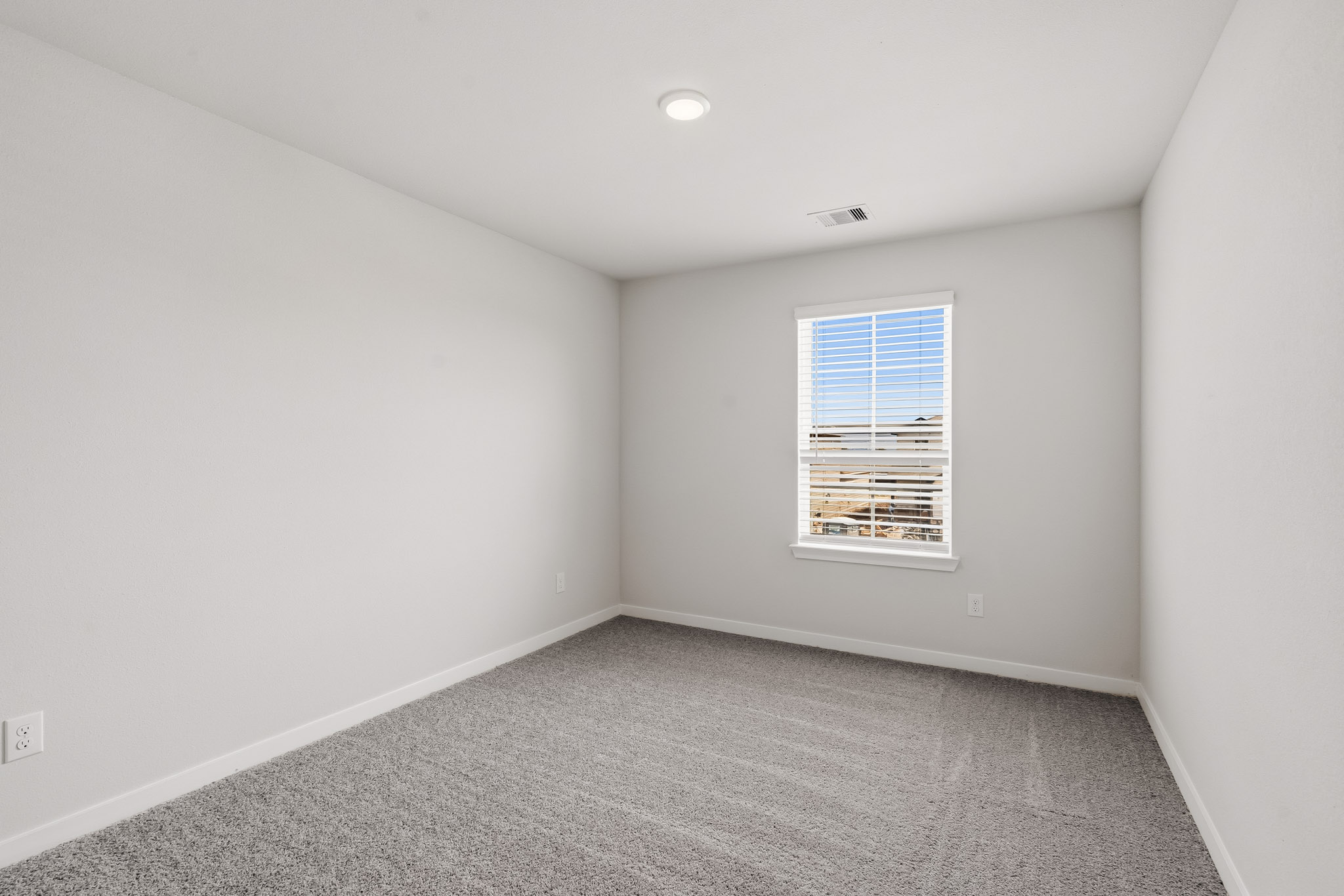 A room with a window and a carpet.