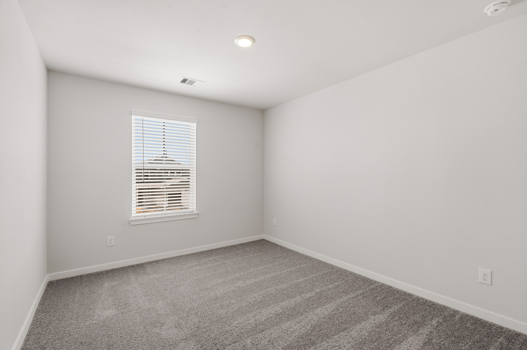 A room with a window and a carpet.