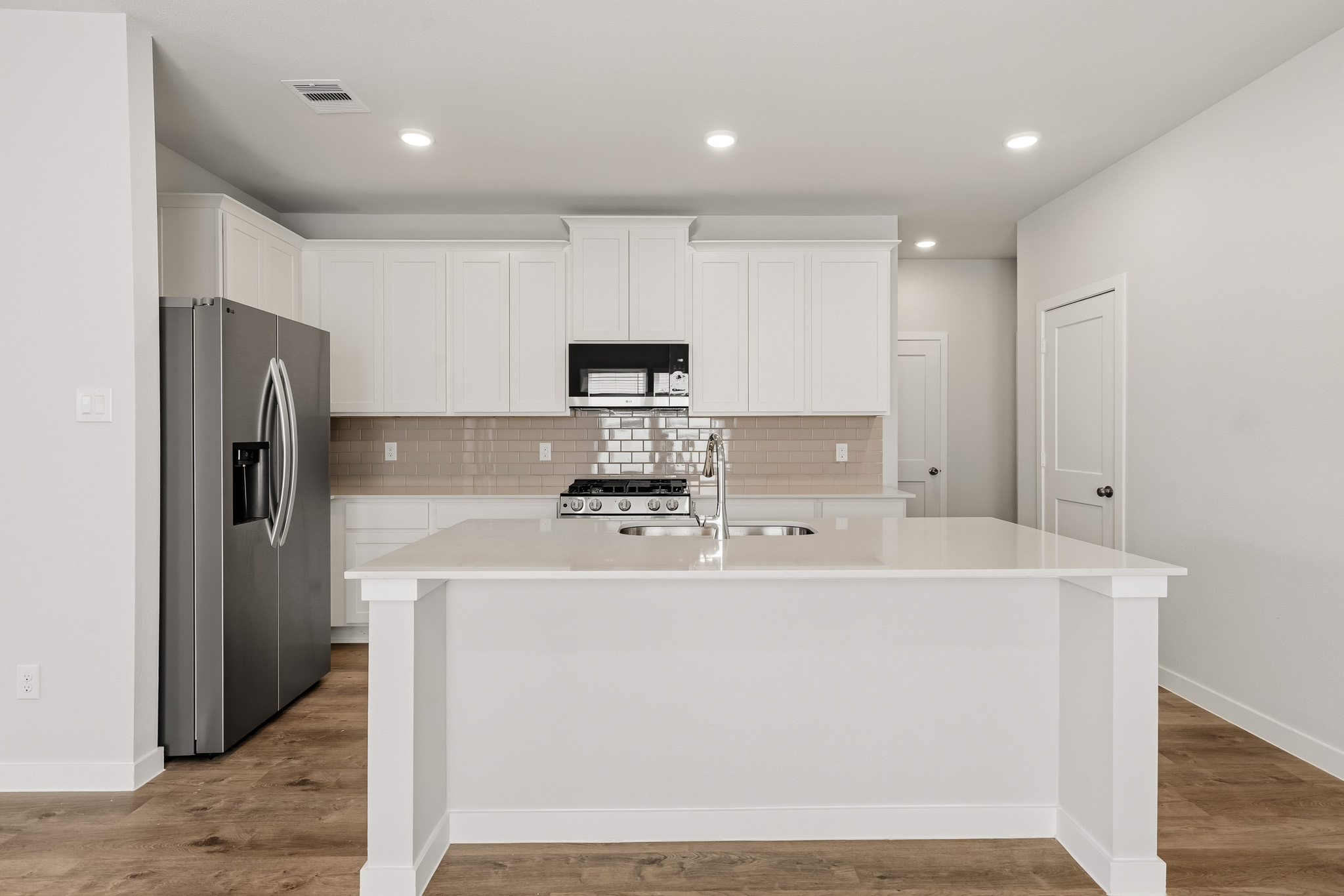 A kitchen with white cabinets.