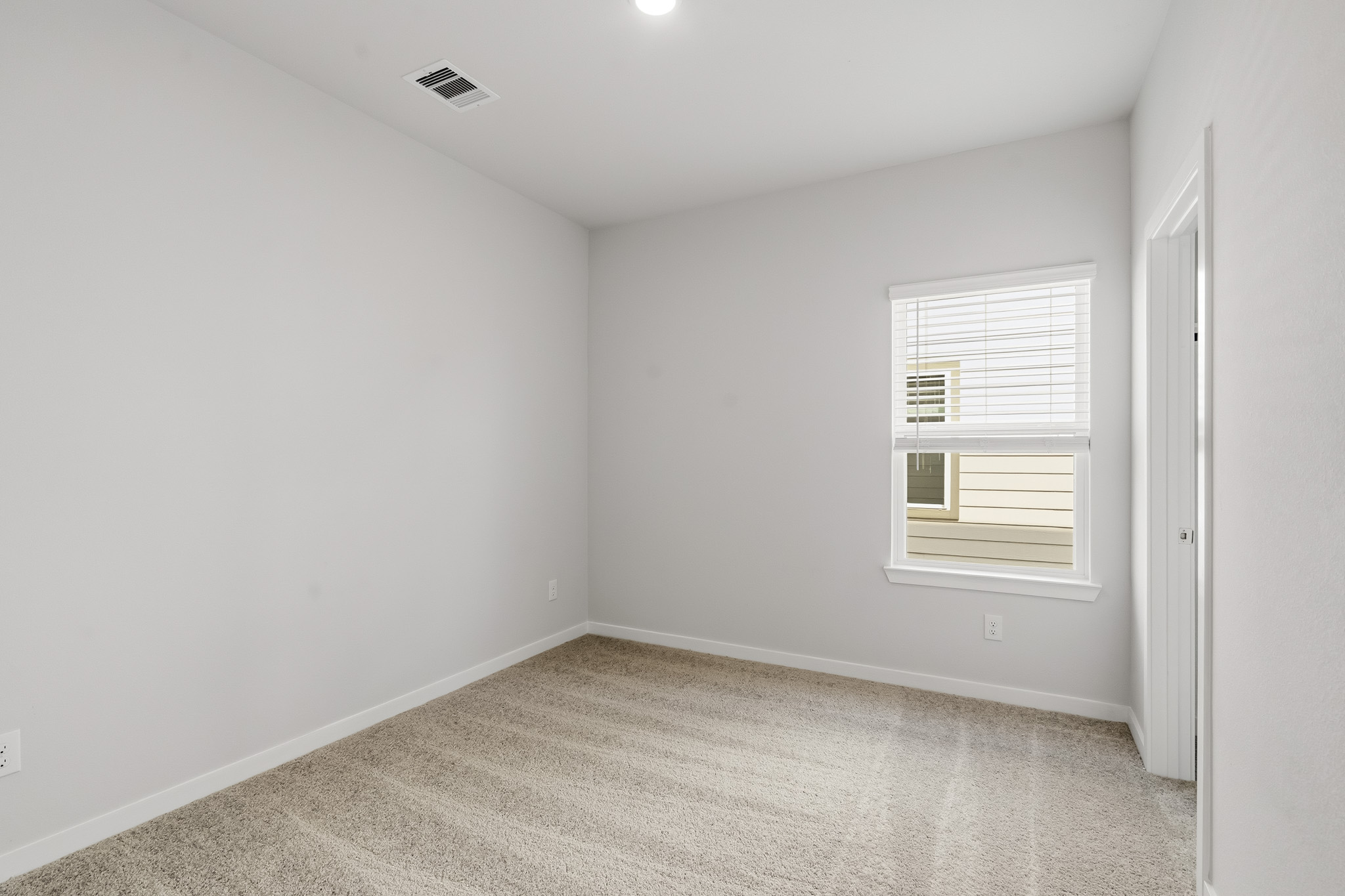 A room with a window and a carpet.