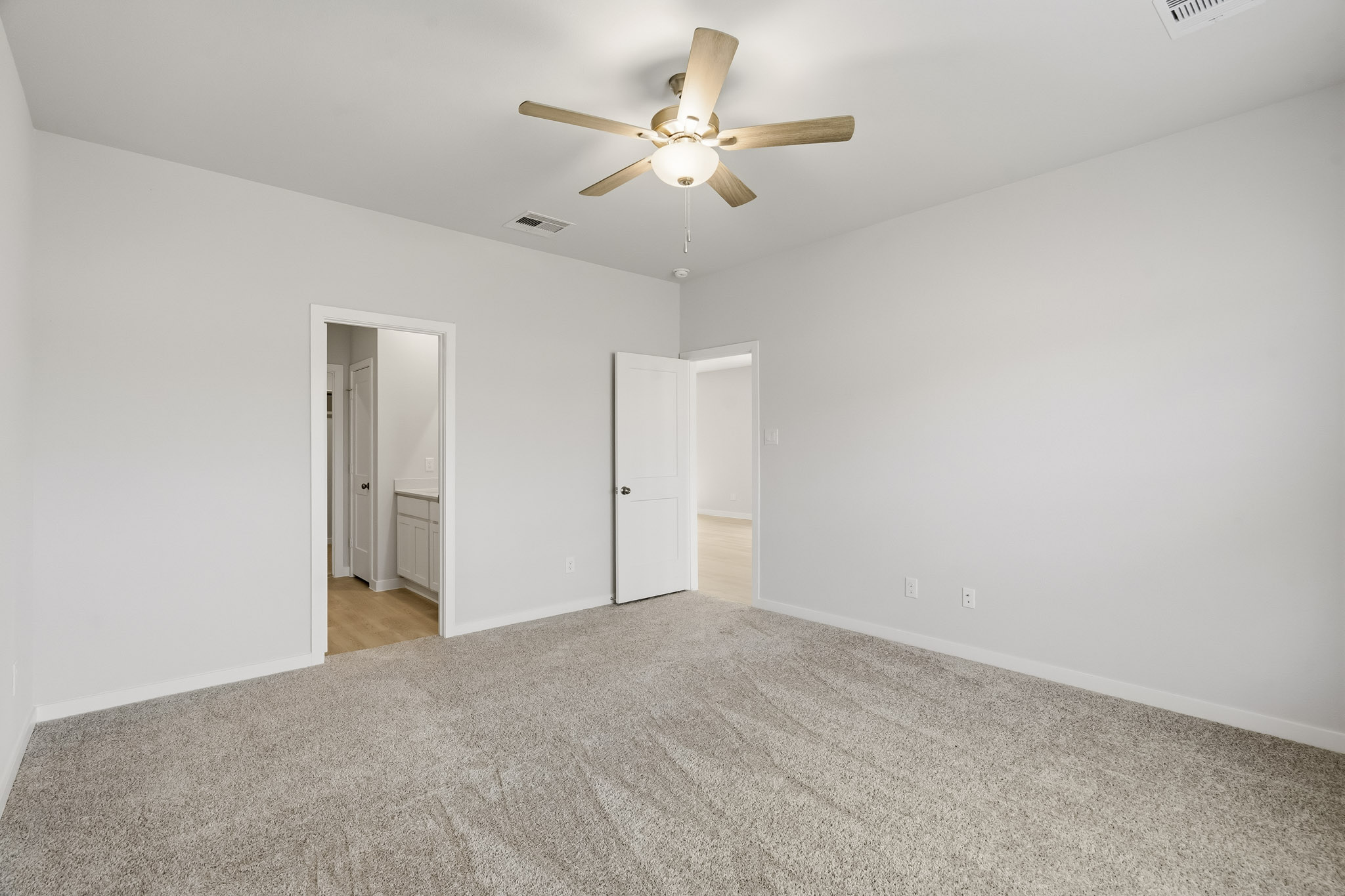 A room with a ceiling fan and a door.