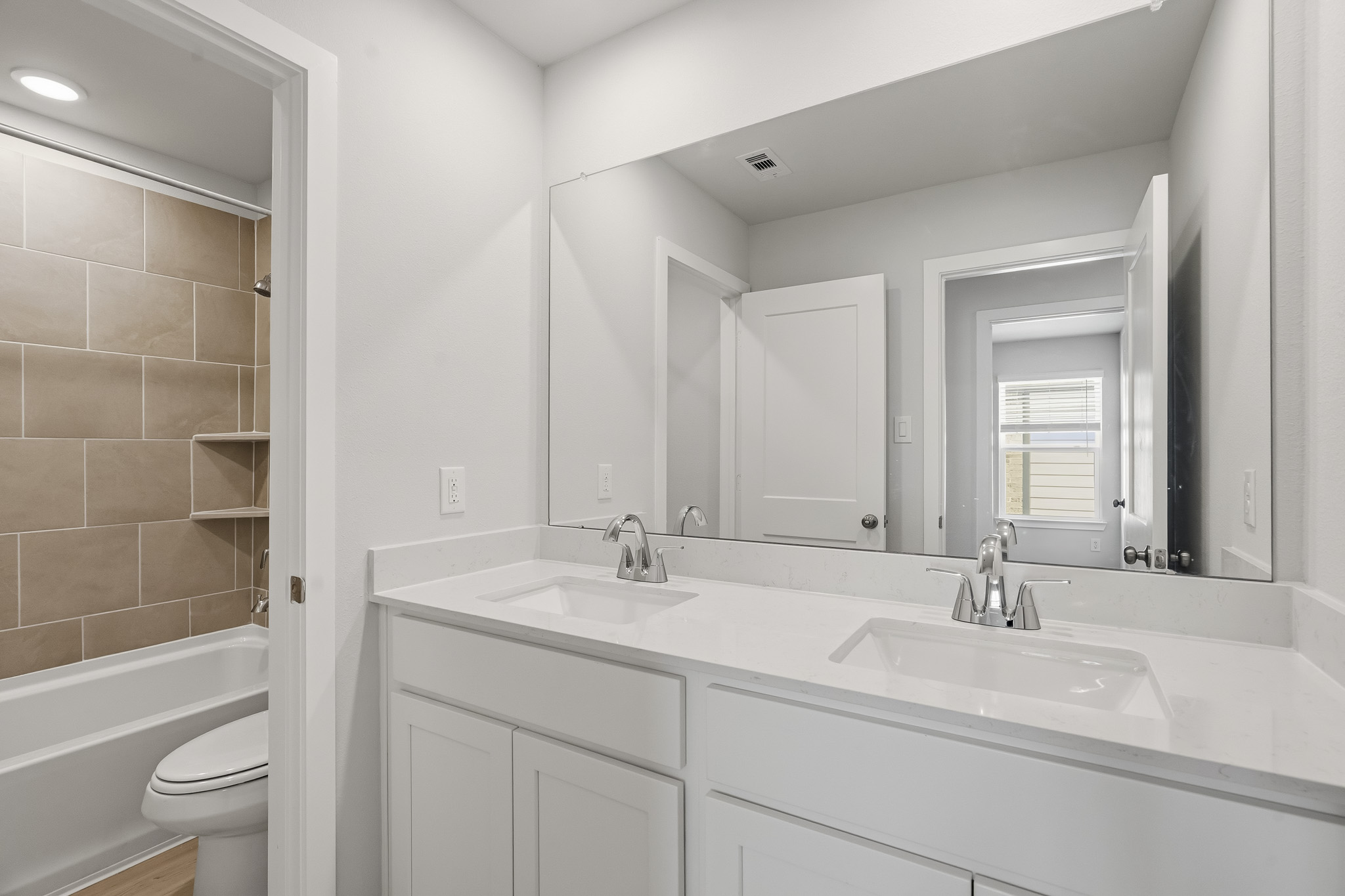 A bathroom with a large mirror.