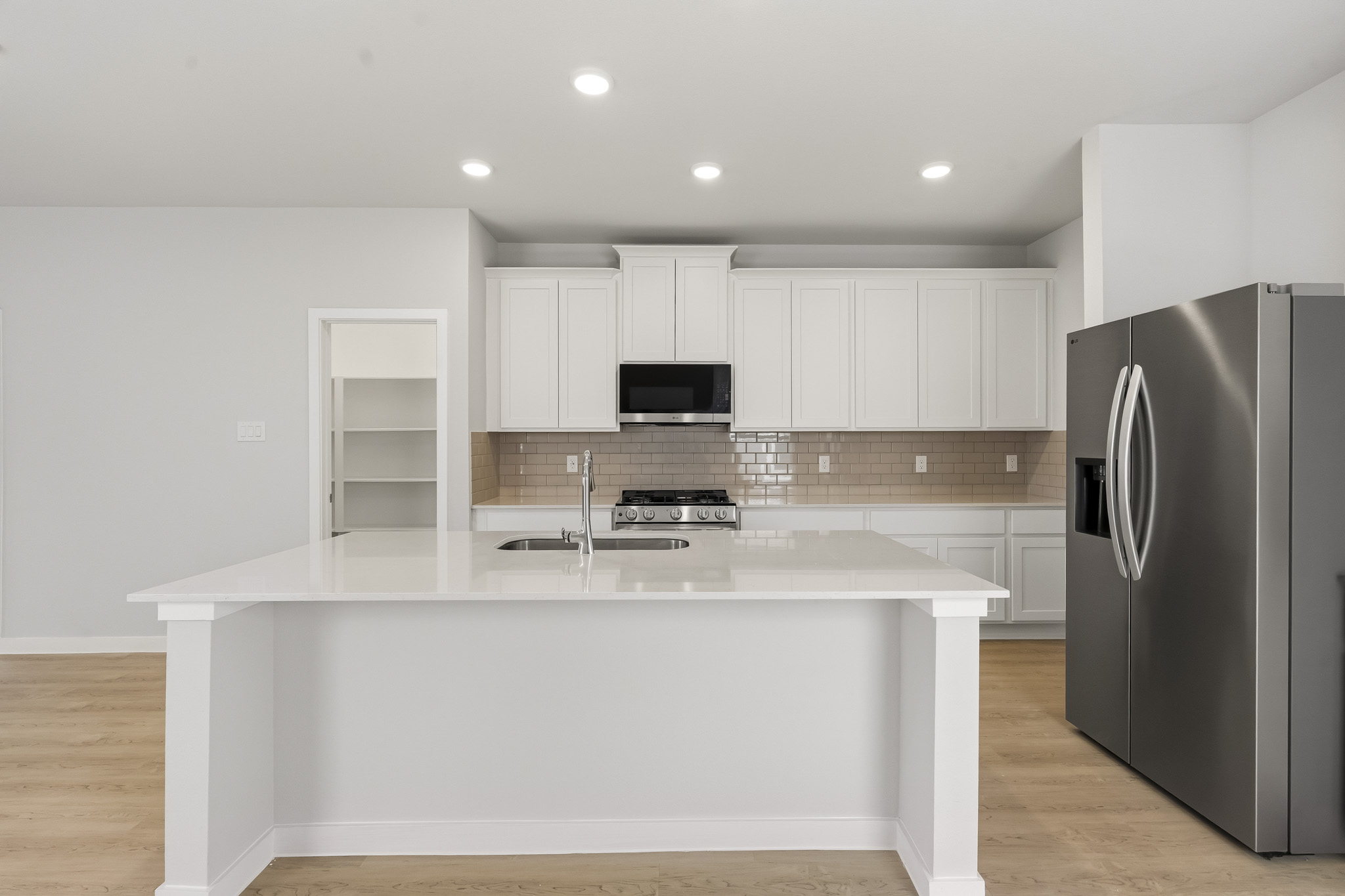 A kitchen with white cabinets.