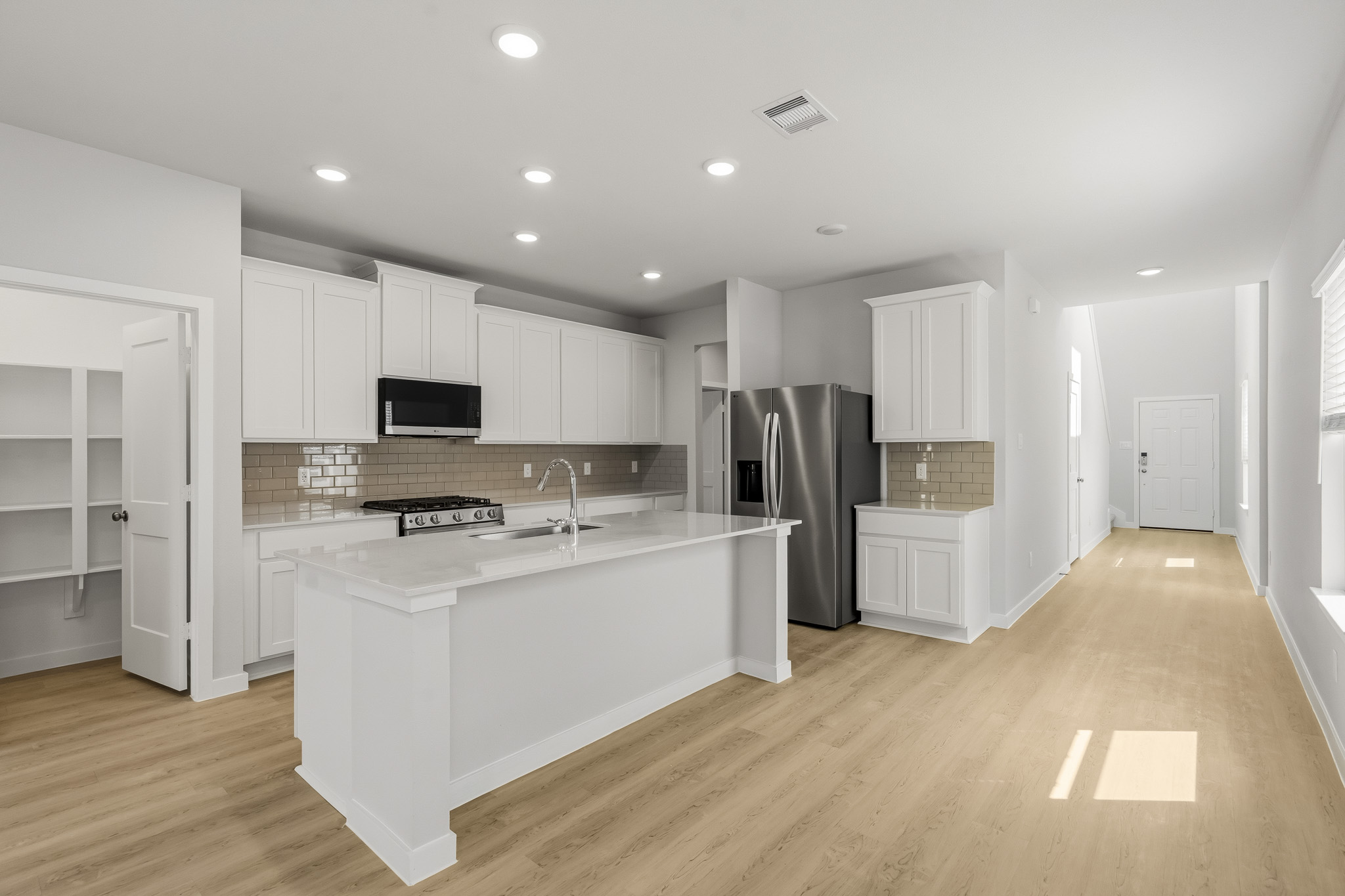 A kitchen with white cabinets.