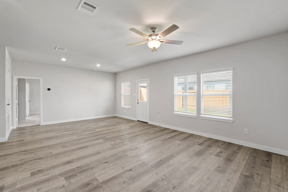 A room with a wood floor and a ceiling fan.