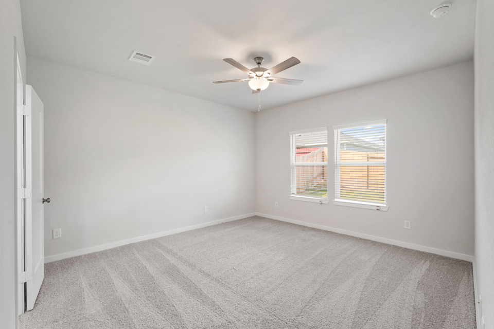 A room with a ceiling fan and a window.