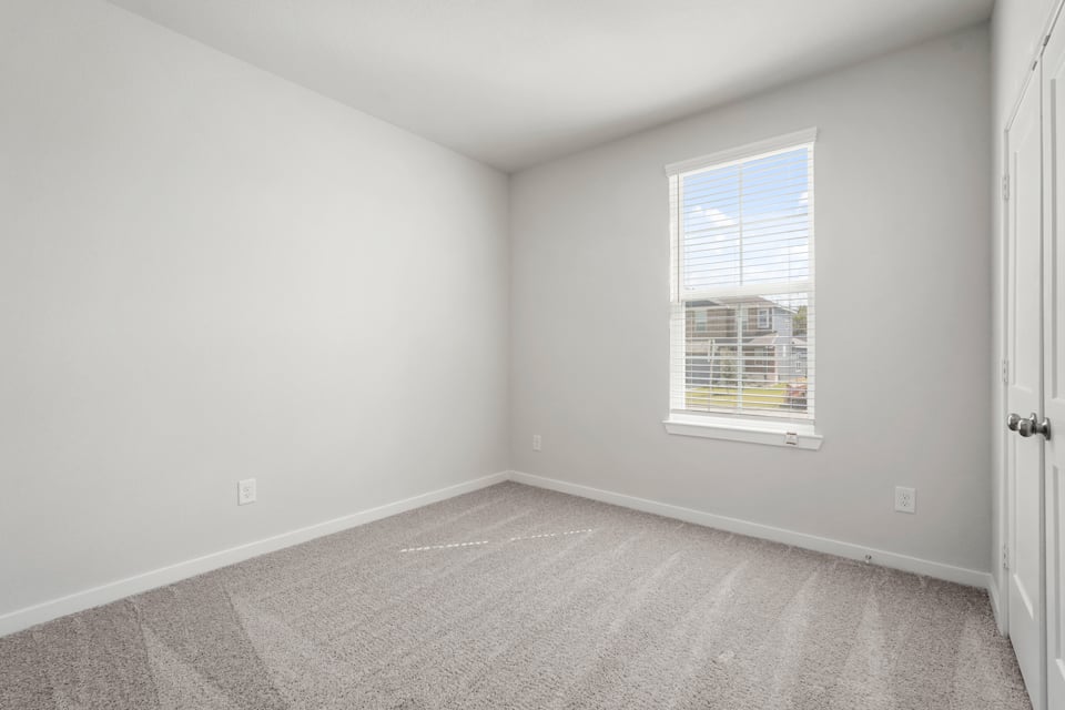 A room with a window and a carpet.