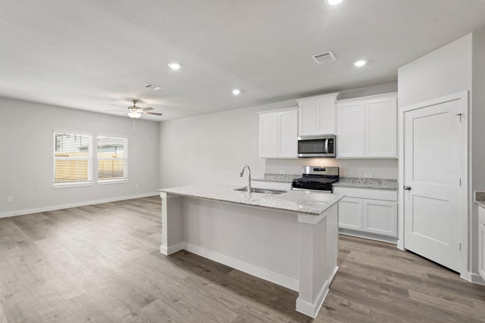 A kitchen with white cabinets.