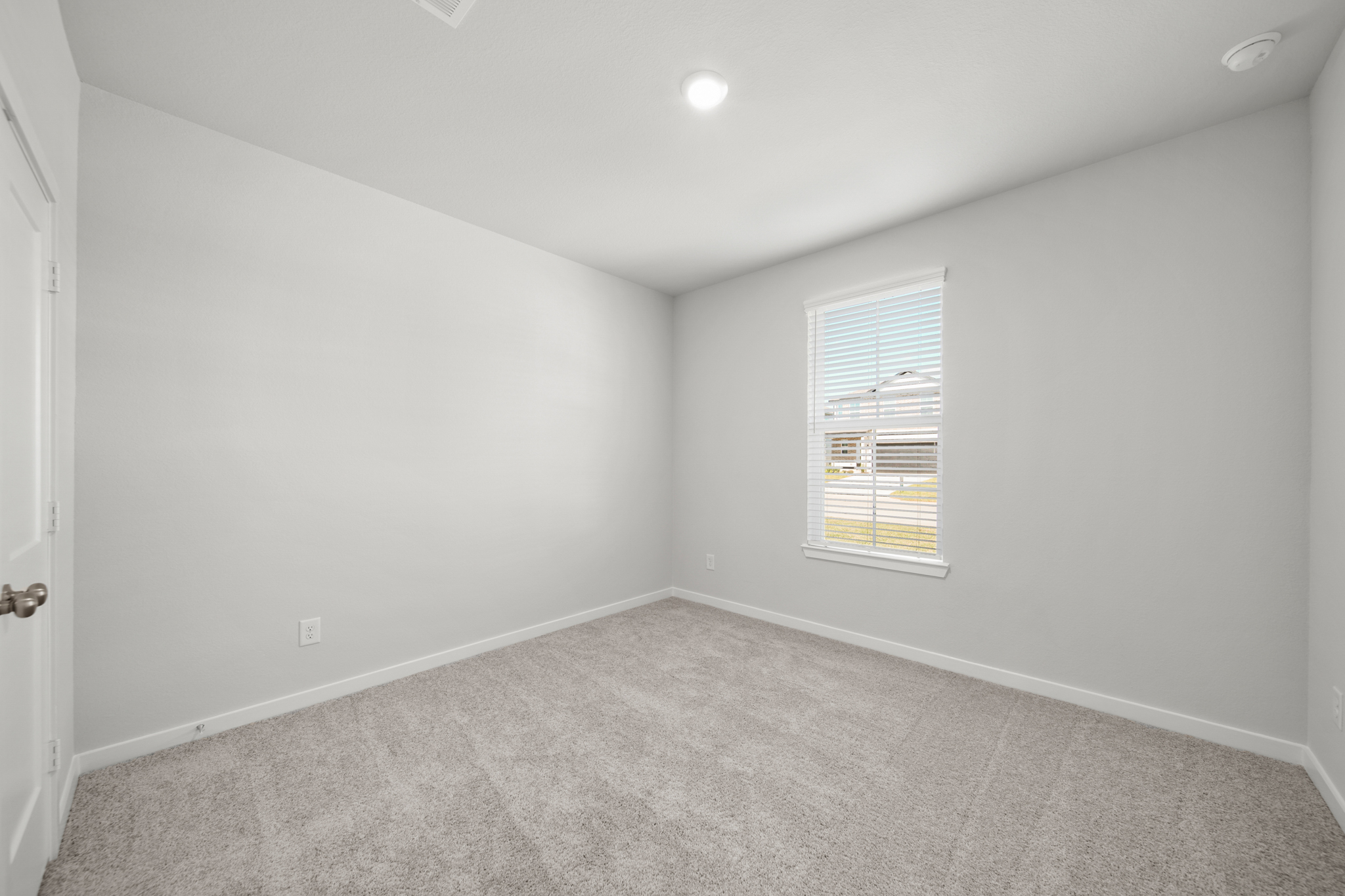 A room with a window and a carpet.