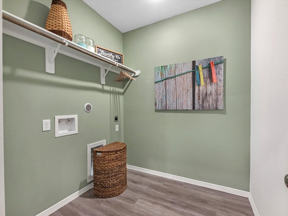 A room with a shelf and a basket on the wall.