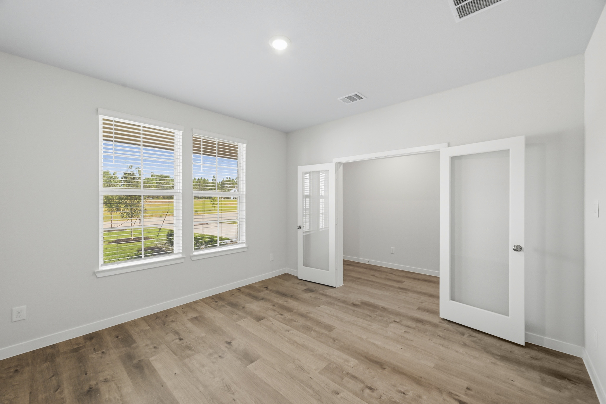A room with a wood floor and windows.