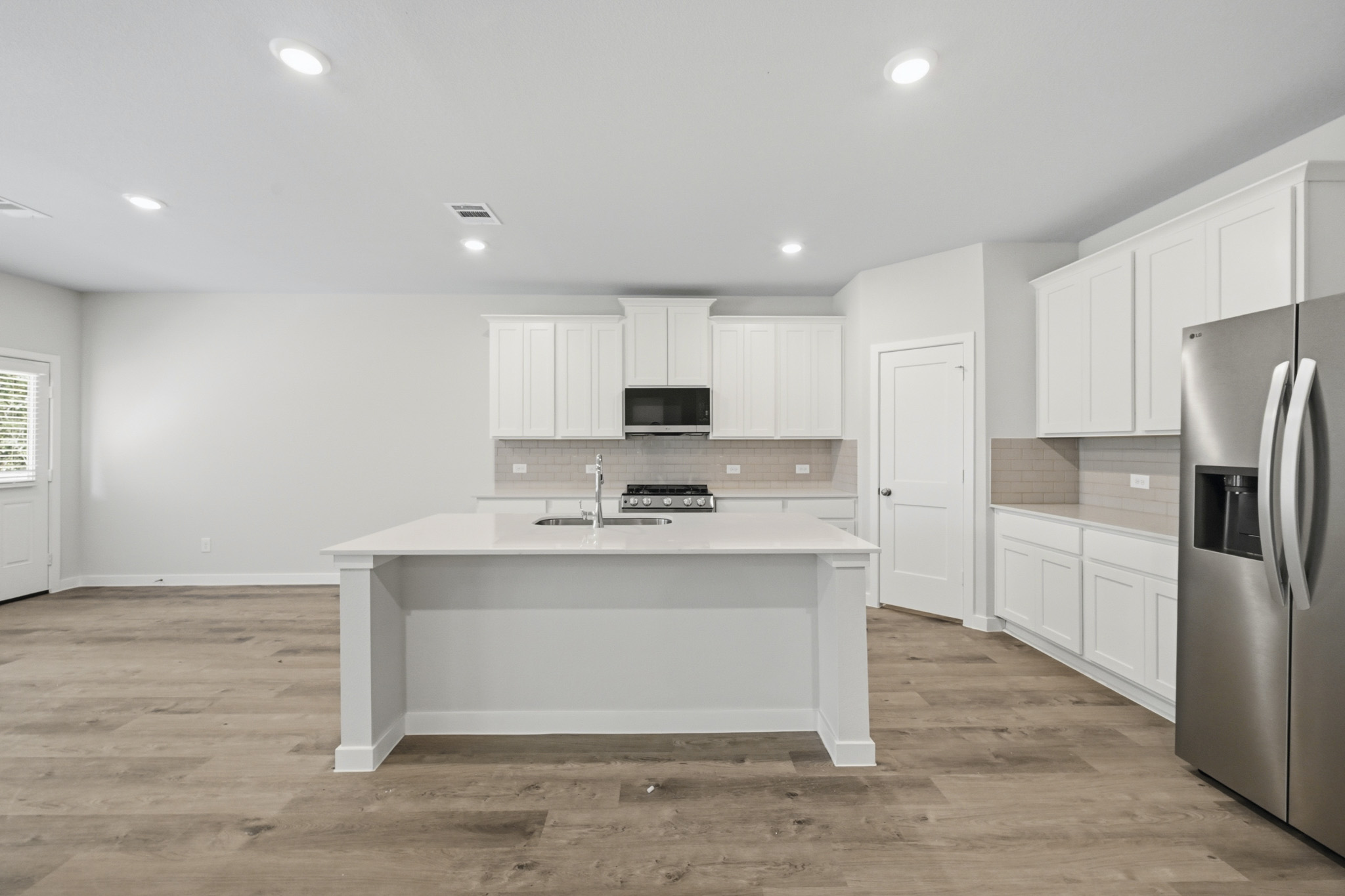 A kitchen with white cabinets.