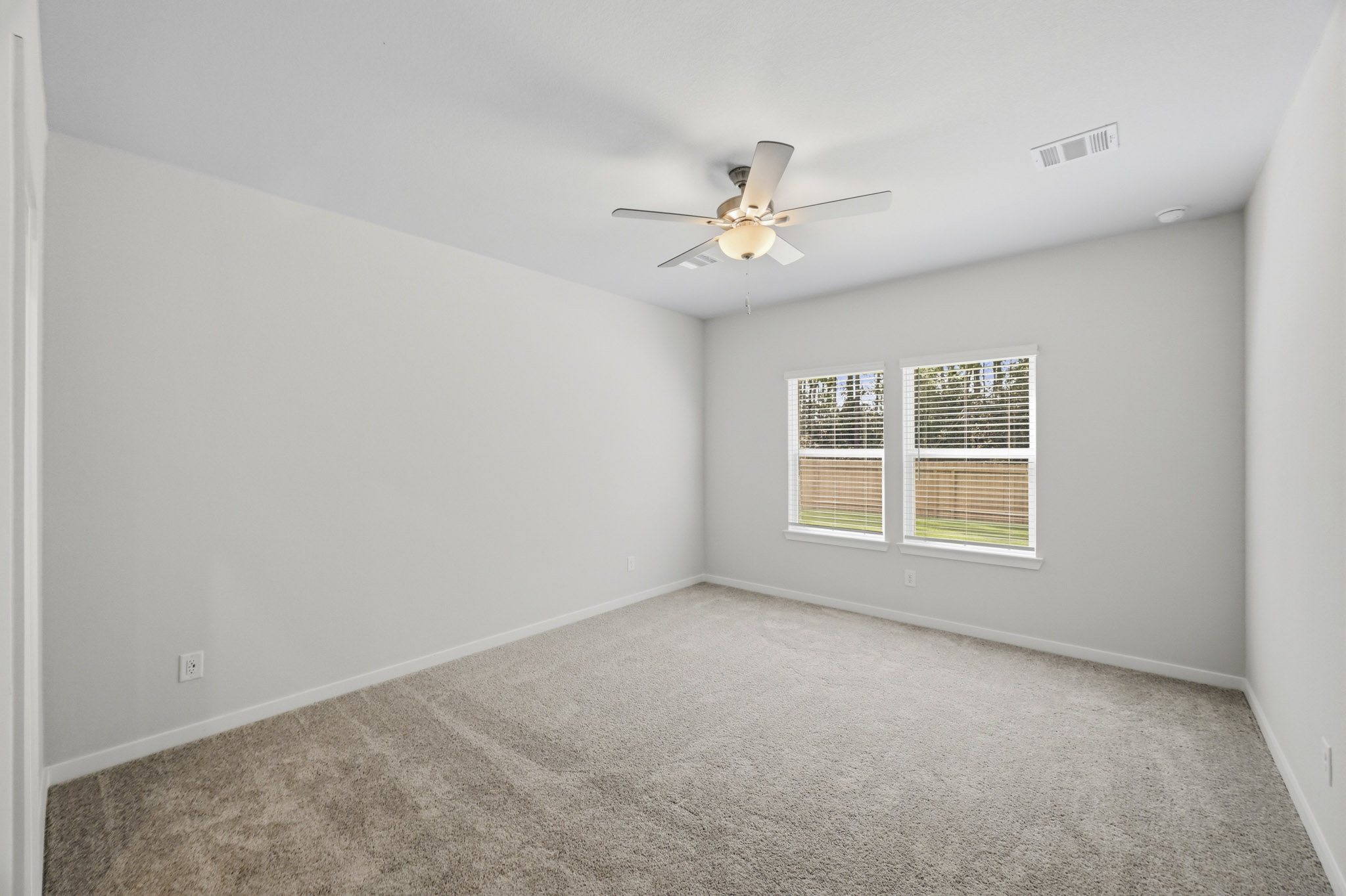 A room with a ceiling fan and a window.