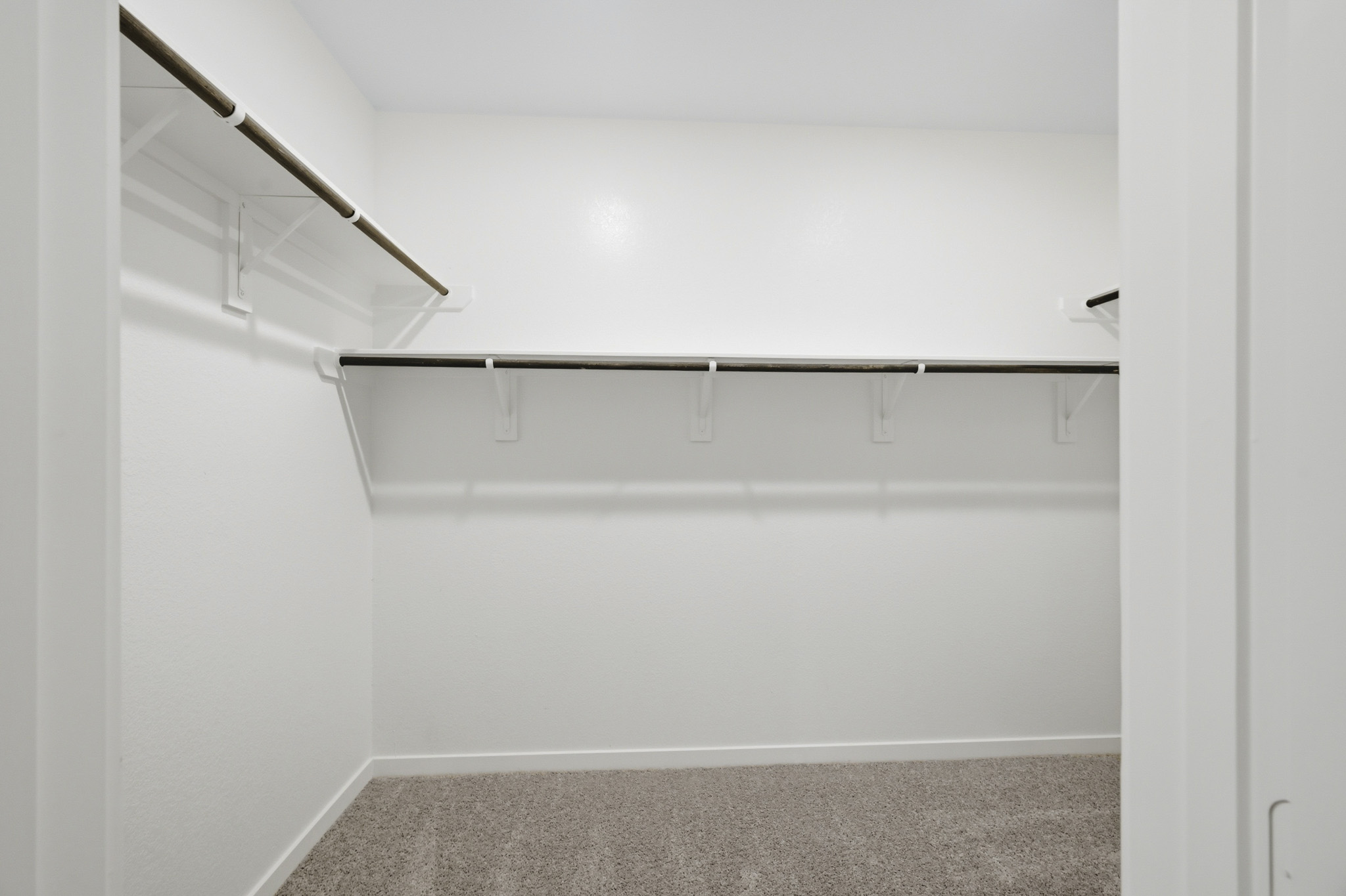 A white wall with a metal bar.