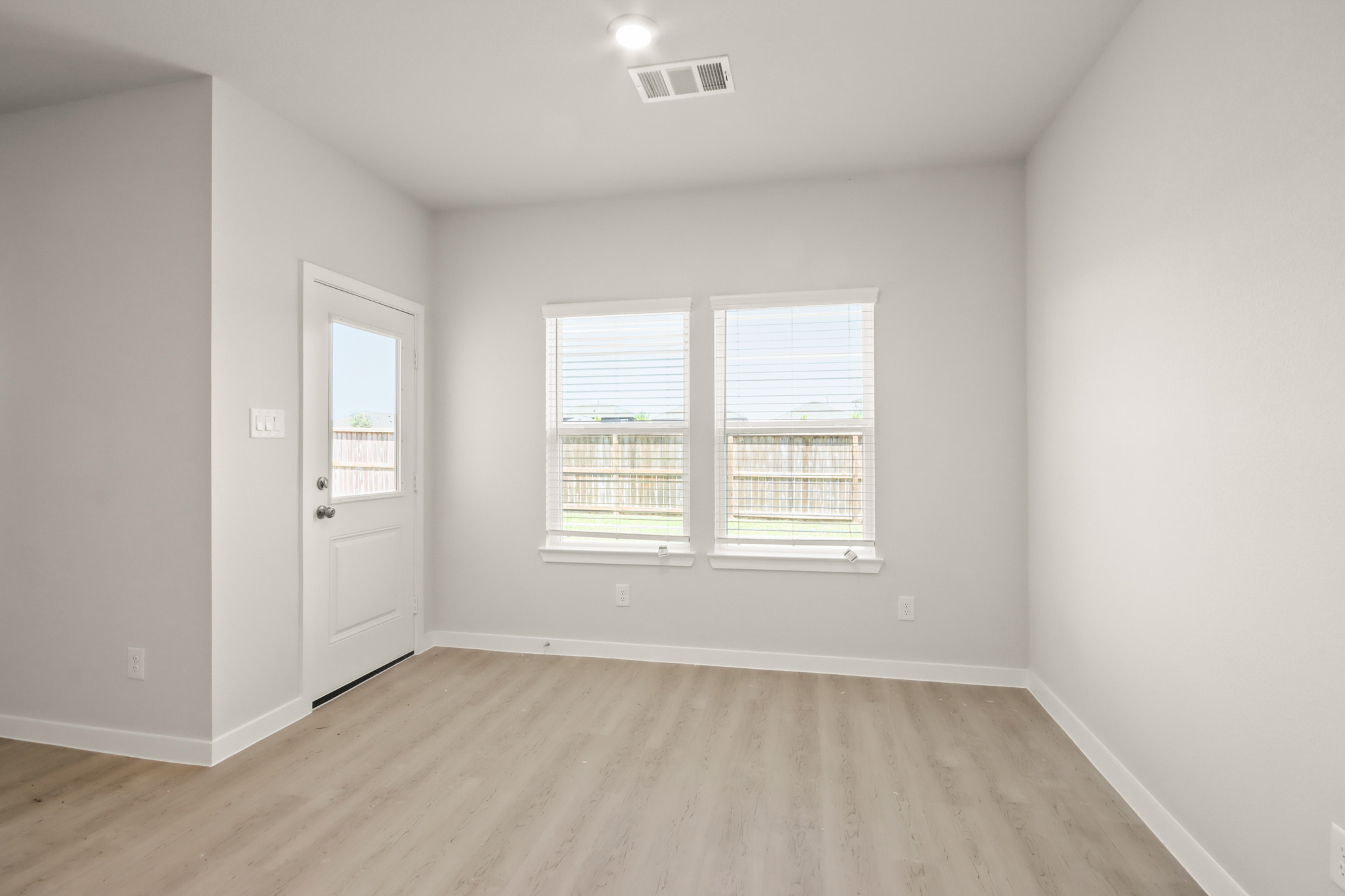 A room with a wood floor and a white door.