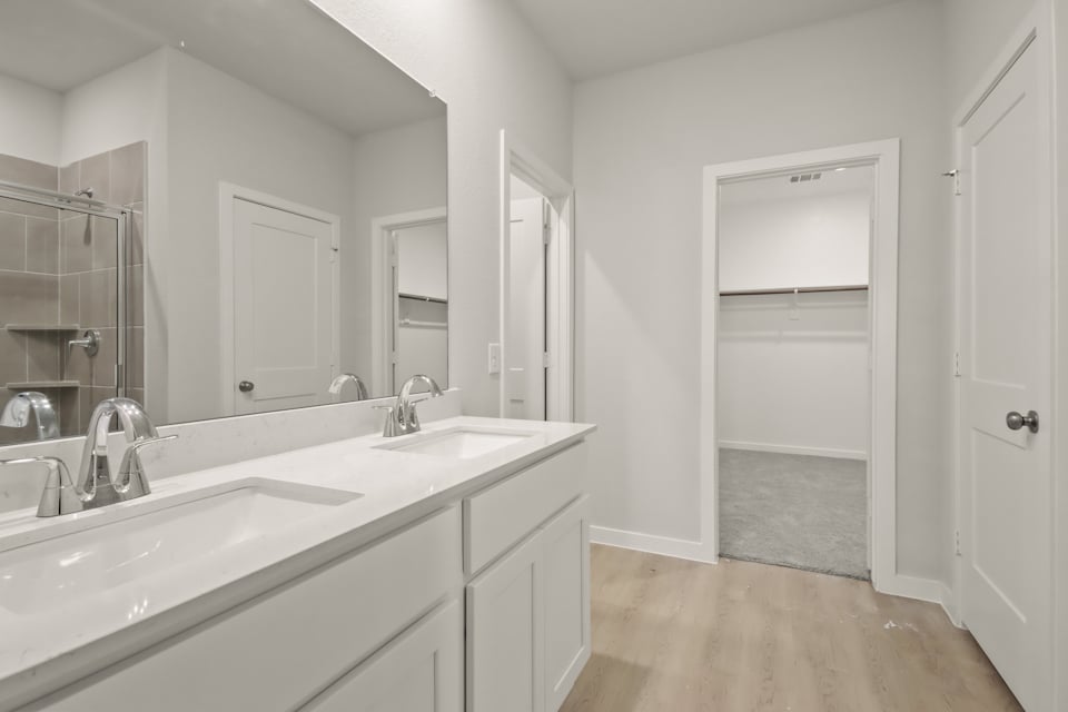 A bathroom with white cabinets.