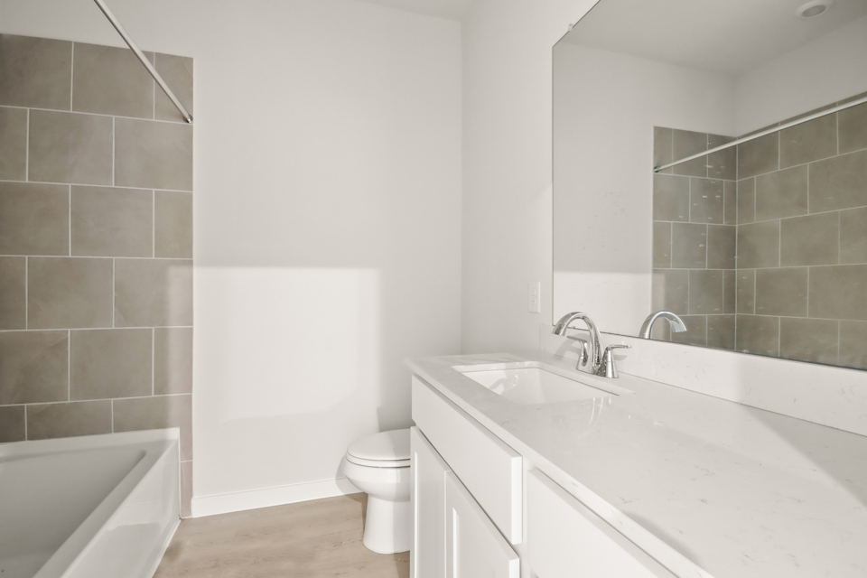 A bathroom with a tub sink and toilet.