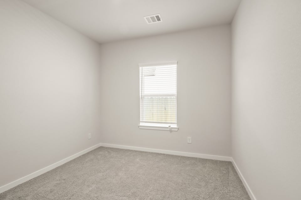 A room with a window and a carpet.