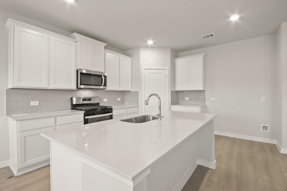 A kitchen with white cabinets.