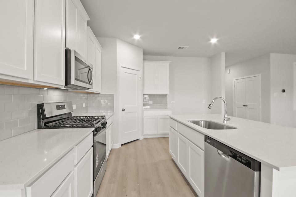 A kitchen with white cabinets.