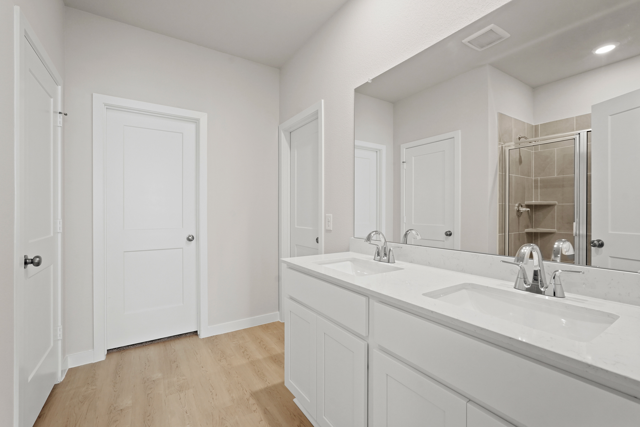 A bathroom with white cabinets.