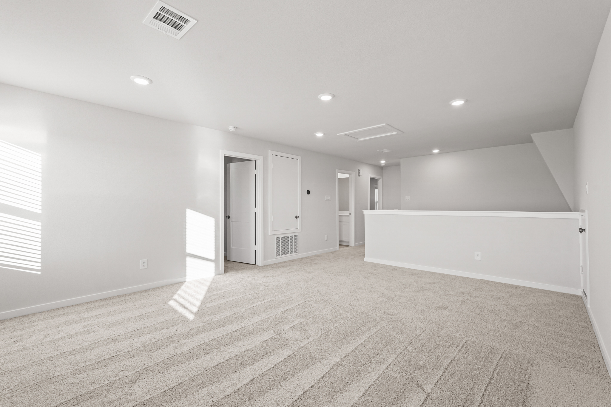 A long hallway with white doors.