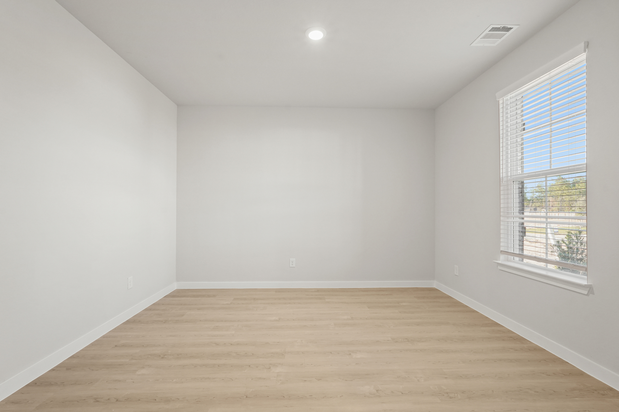 A room with a wood floor and windows.