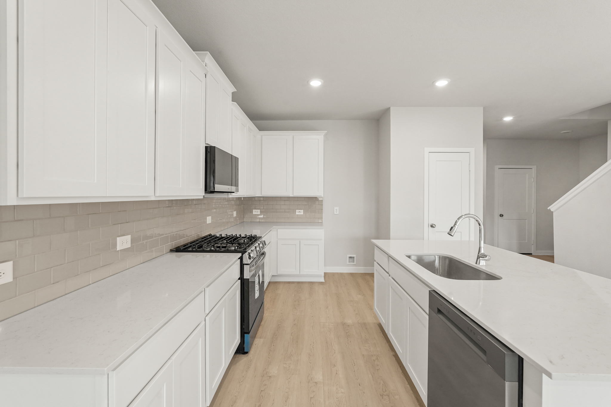 A kitchen with white cabinets.