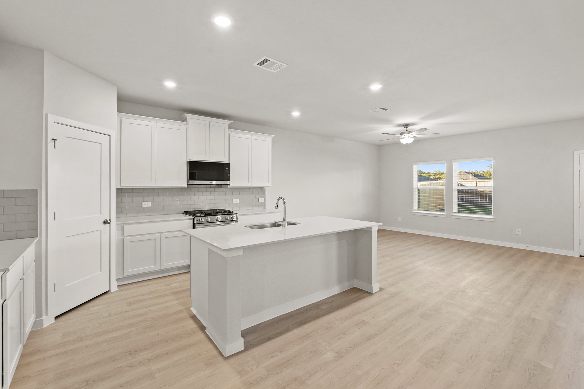 A kitchen with white cabinets.